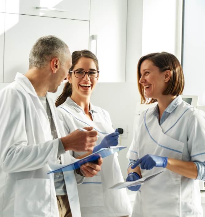 Three dental team members discussing dental patient treatment plan