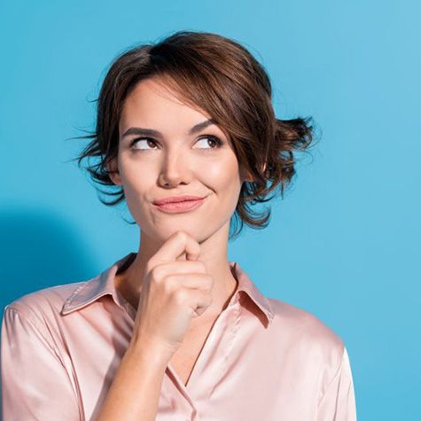 Woman wearing curious expression, positioned in front of blue background