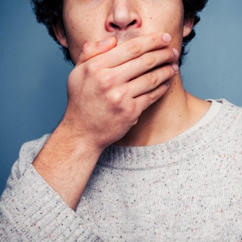 Lower half of man’s face, hand covering mouth