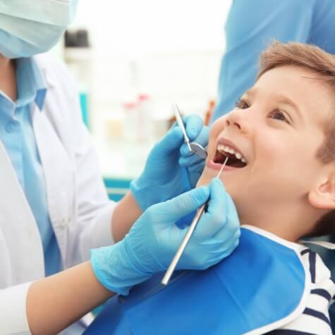 Young patient receiving dental checkup and teeth cleaning for kids