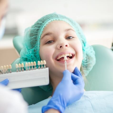 Patient's smile compared with tooth colored filling shade chart