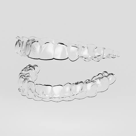 Clear aligners for top and bottom teeth against neutral background