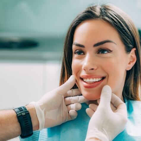 Dentist examining paient's smiles after Lumineers