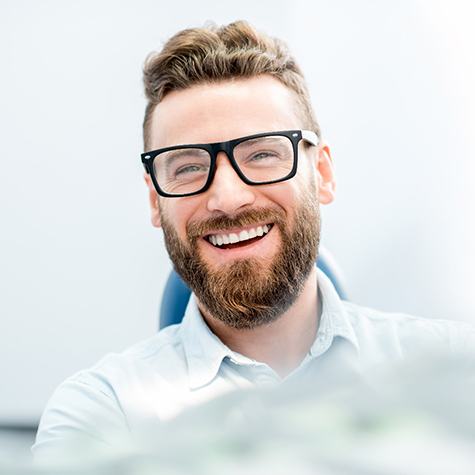 man smiling after getting dental crowns in McKinney