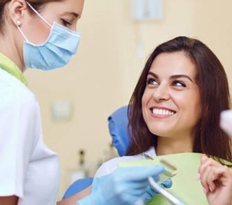 Dentist and patient discussing the cost of dental implant tooth replacement