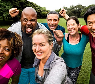 Group of adults outside in park laughing while taking selfie