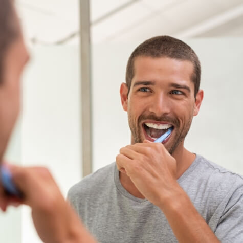 Man brushing teeth to prevent dental emergencies