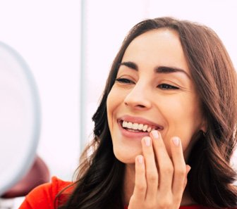 A woman admiring her new dental implants