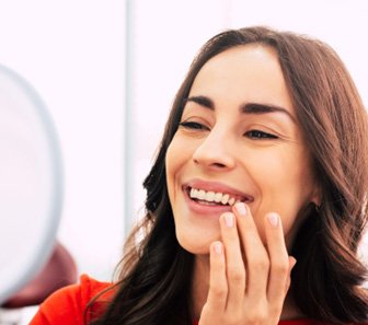 A woman admiring her new dental implants 