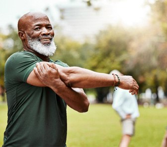 An older man who’s warming up outdoors 