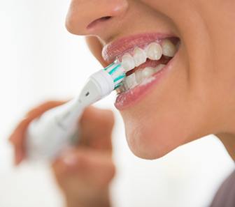 Nose-to-chin profile view of someone brushing their teeth