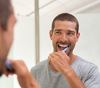 Patient in McKinney brushing their dental implants