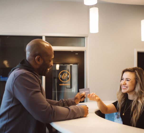 Dental team member taking payment card from dental patient in McKinney