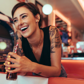 Woman with short hair laughing in restaurant