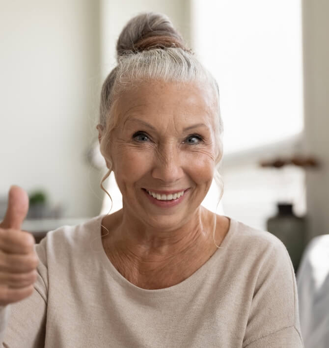 Woman visiting dental insurance dentist giving thumbs up