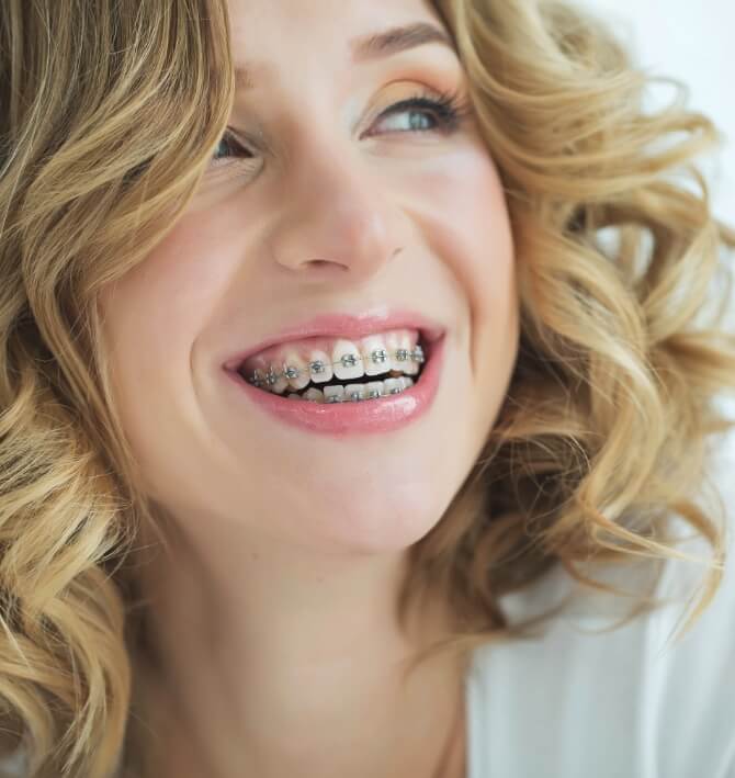 Woman with traditional orthodontics smiling