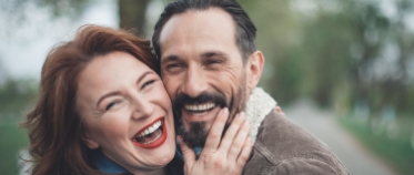 Man and woman sharing healthy smiles after restorative dentistry