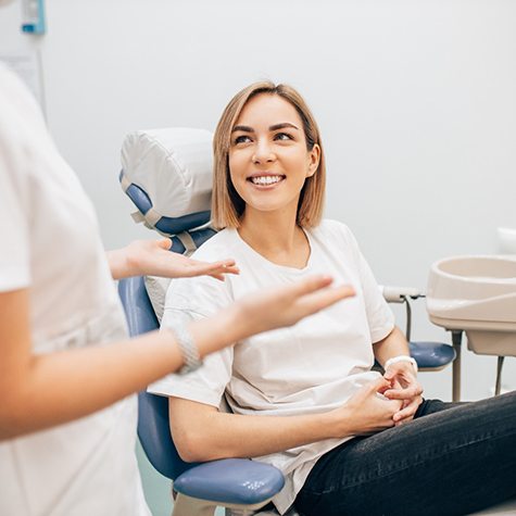 woman talking to dentist about cost of veneers in McKinney