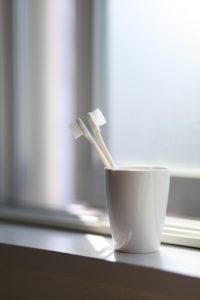 Toothbrushes in white cup
