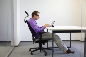 Man sitting at desk with bad posture