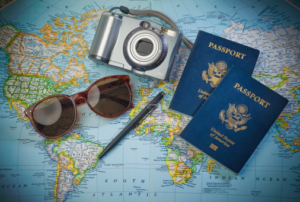 Sunglasses, a camera, and passports resting on top of a world map